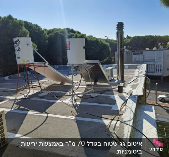 איטום גג עם חומר לבן, דודי שמש וצינורות.